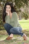 Latina chick Bella Quinn climbs a tree in the park wearing a sweater and jeans