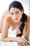 Alluring brunette Kissa Sins wears her long hair in ponytail while posing nude