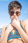 Amateur girl with short hair frees her pert tits from bikini top in sunglasses