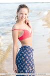 Adorable teen Faina Bona gets naked on the beach before oiling her cute pussy