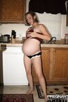 Pregnant amateur removes a tube top before slipping out of sexy panties