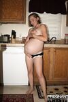 Pregnant amateur removes a tube top before slipping out of sexy panties
