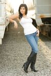 Black-haired bombshell Sunny Leone in white shirts, blue jeans, and high boots