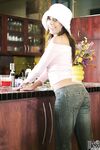 Big boobed MILF Penny Flame strips and poses provocatively in the kitchen