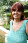 Redhead granny Livia lifts her blue dress up and reveals big natural tits