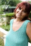 Redhead granny Livia lifts her blue dress up and reveals big natural tits