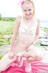 Blonde cutie Runa removes her shorts outdoors and gets on her knees naked