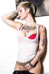Tattooed model Kleio Valentien takes off clothes and boots to model naked