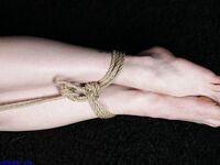 Naked blonde finds her nipples sticking out as she struggles against rope ties