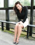 Fully clothed woman Donna slips off her black heels while waiting for a bus