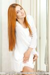 Beautiful girl with long red hair Carinela strikes nude poses afore a mirror