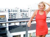 Mature blonde Molly MILF sets her large boobs free of red dress in solo action