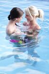 Pretty girls Anneli & Caprice kissing and touching perky wet tits in the pool