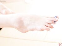 Japanese woman exposes her feet with blue nail polish while masturbating