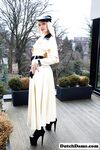 Classy blonde flashes the village below on her patio in latex attire