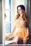 Nice teen Nasita undresses on her bed for nude poses on a window sill