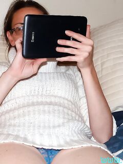 Amateur woman takes off her sweater while showing her lace panties on a bed