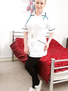 Pretty big boobed nurse Emma Rachael gets rid of uniform and poses topless