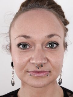 Pierced and tattooed amateur Petra stands naked after removing her clothes