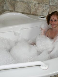 Young looking redhead Alyssa Hart jerks off her stepfather in the bathtub