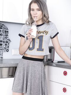 Young Kira J spreads her hairy pussy in the kitchen after a sexy striptease